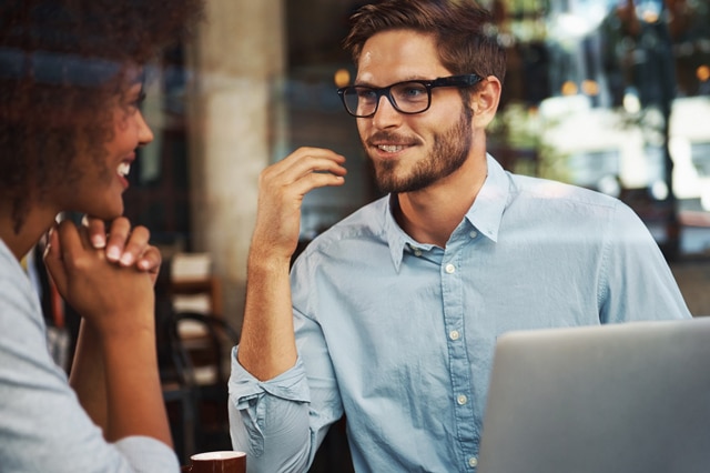 A young man and woman talking and smiling.