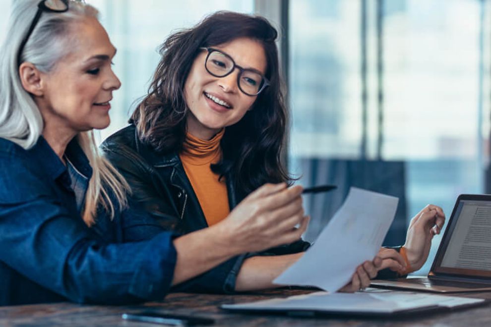 Two professional women reviewing a document