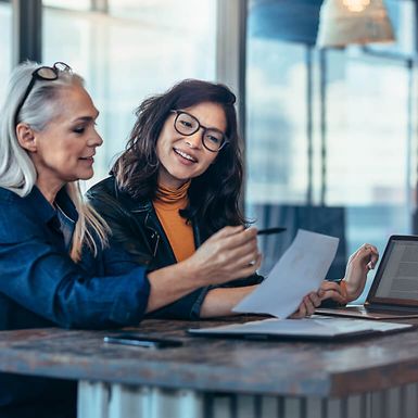 Two professional women reviewing a document