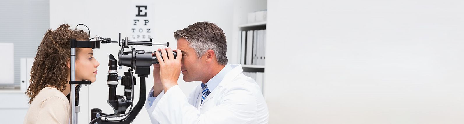 An eye doctor examines a patient's eyes