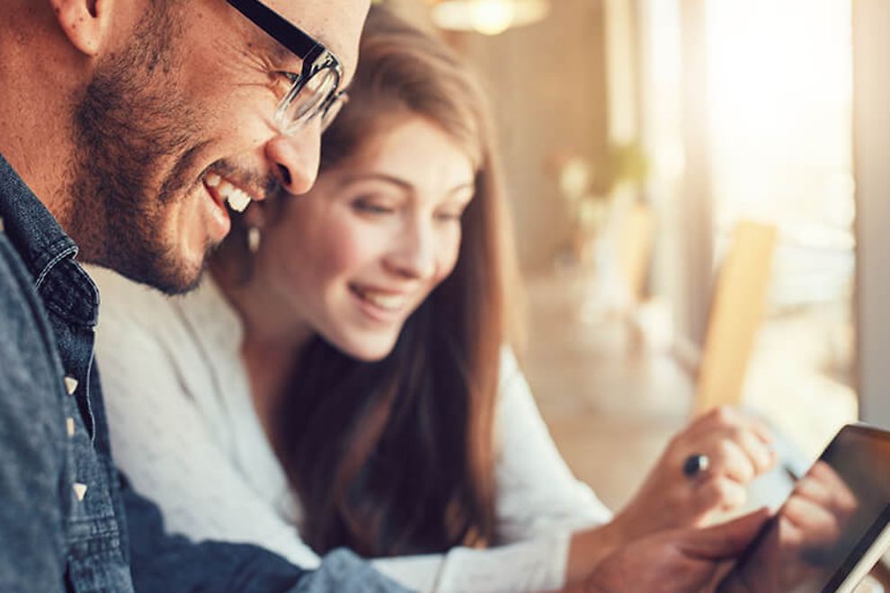 Young man and woman looking at a tablet in a cafe