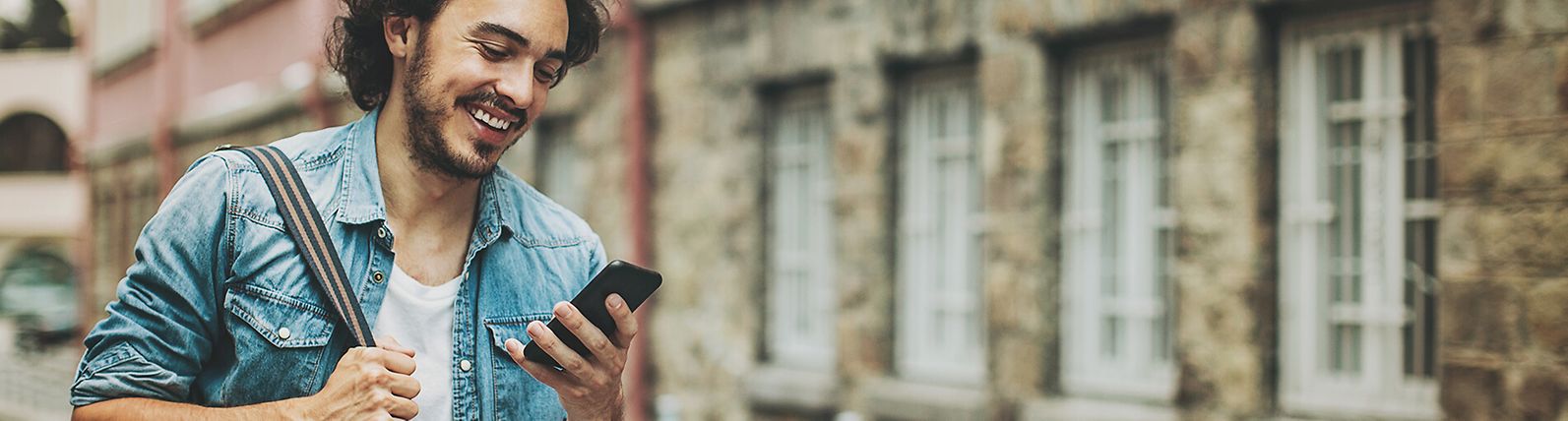 Man looking at his phone in a city environment