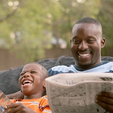 father and son reading and laughing