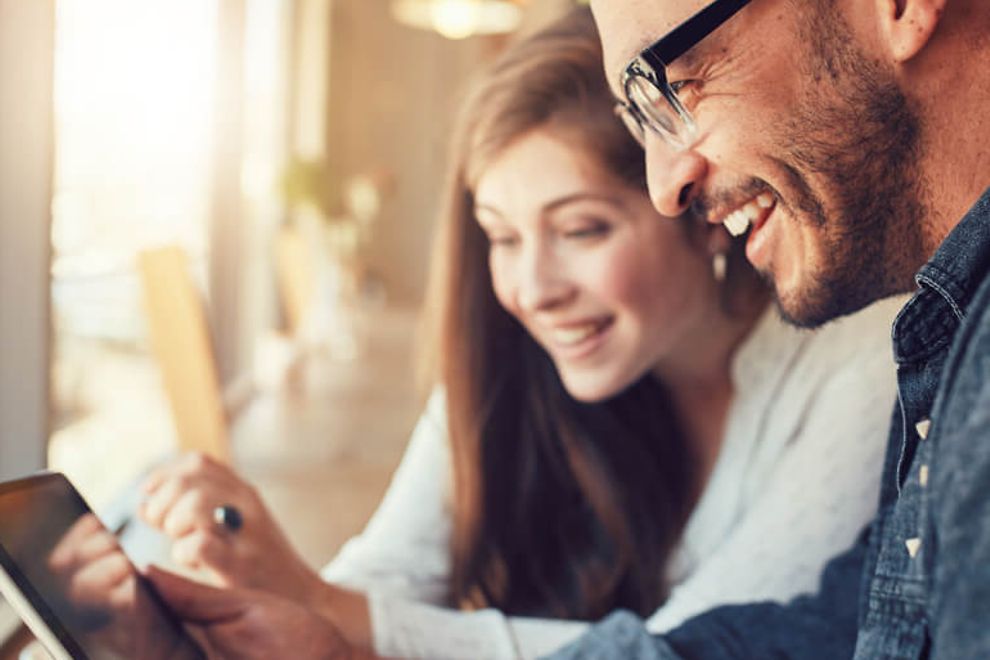 Young man and woman looking at a tablet together.