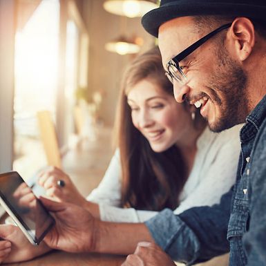 Young man and woman looking at a tablet together.