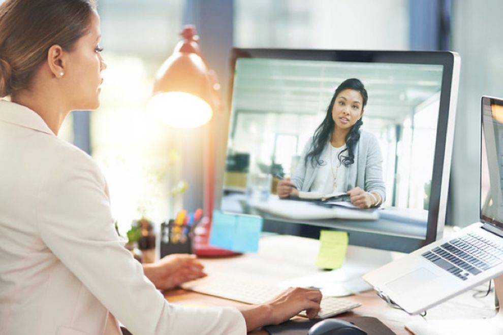 female doctor at desk conducting a telehealth visit on computer