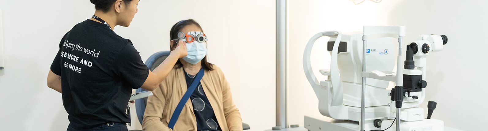 two people in an eye exam clinic, one performing and one taking the exam