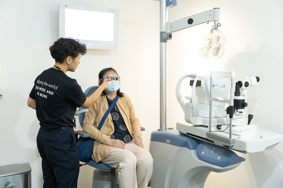 two people in an eye exam clinic, one performing and one taking the exam