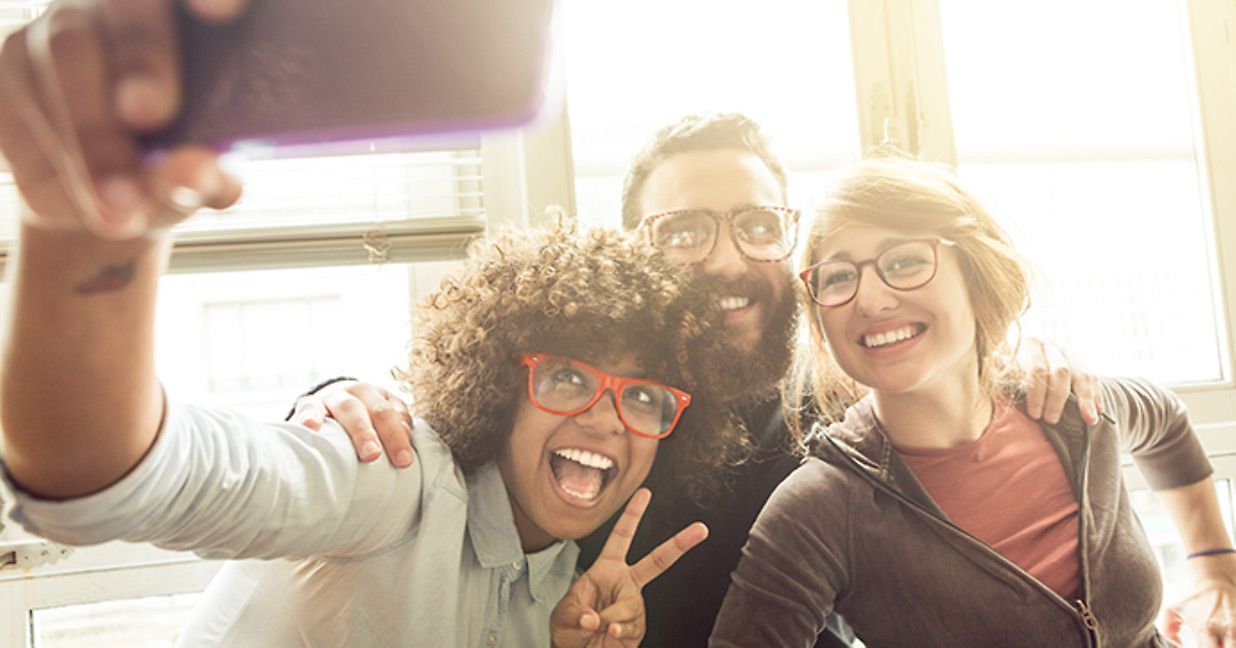 group of 3 friends taking a selfie on smartphone 